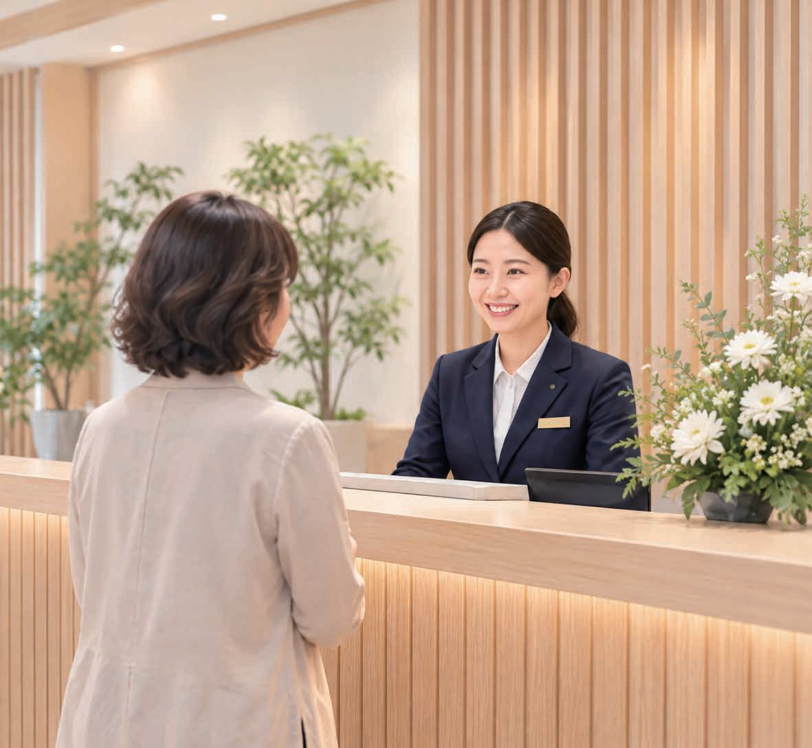 木目のカウンターで来館者を笑顔で迎えるスタッフ